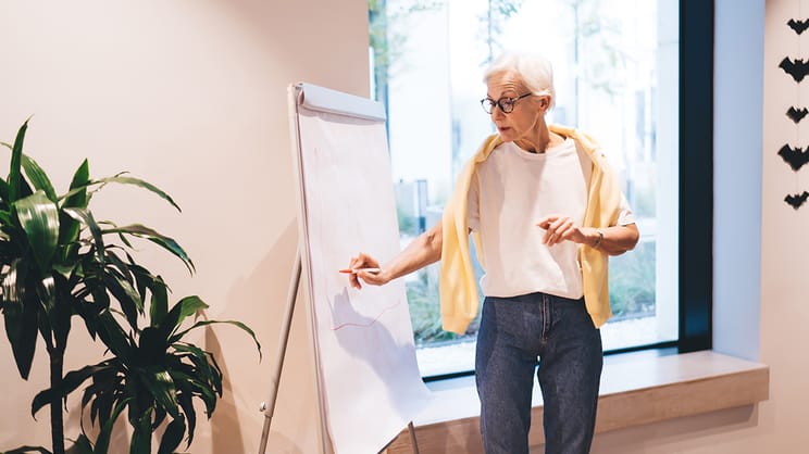Older woman presenting at a whiteboard